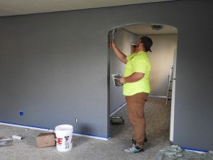 Image of painter applying interior paint but How Often Should You Paint Your House?